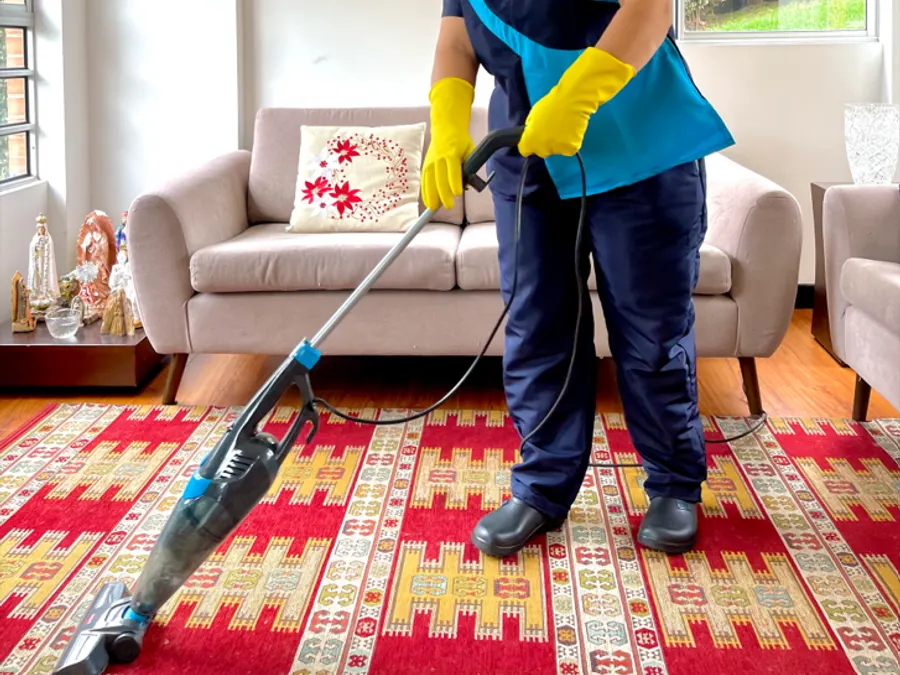 Auxiliar de 4HOME aspirando la sala de un hogar
